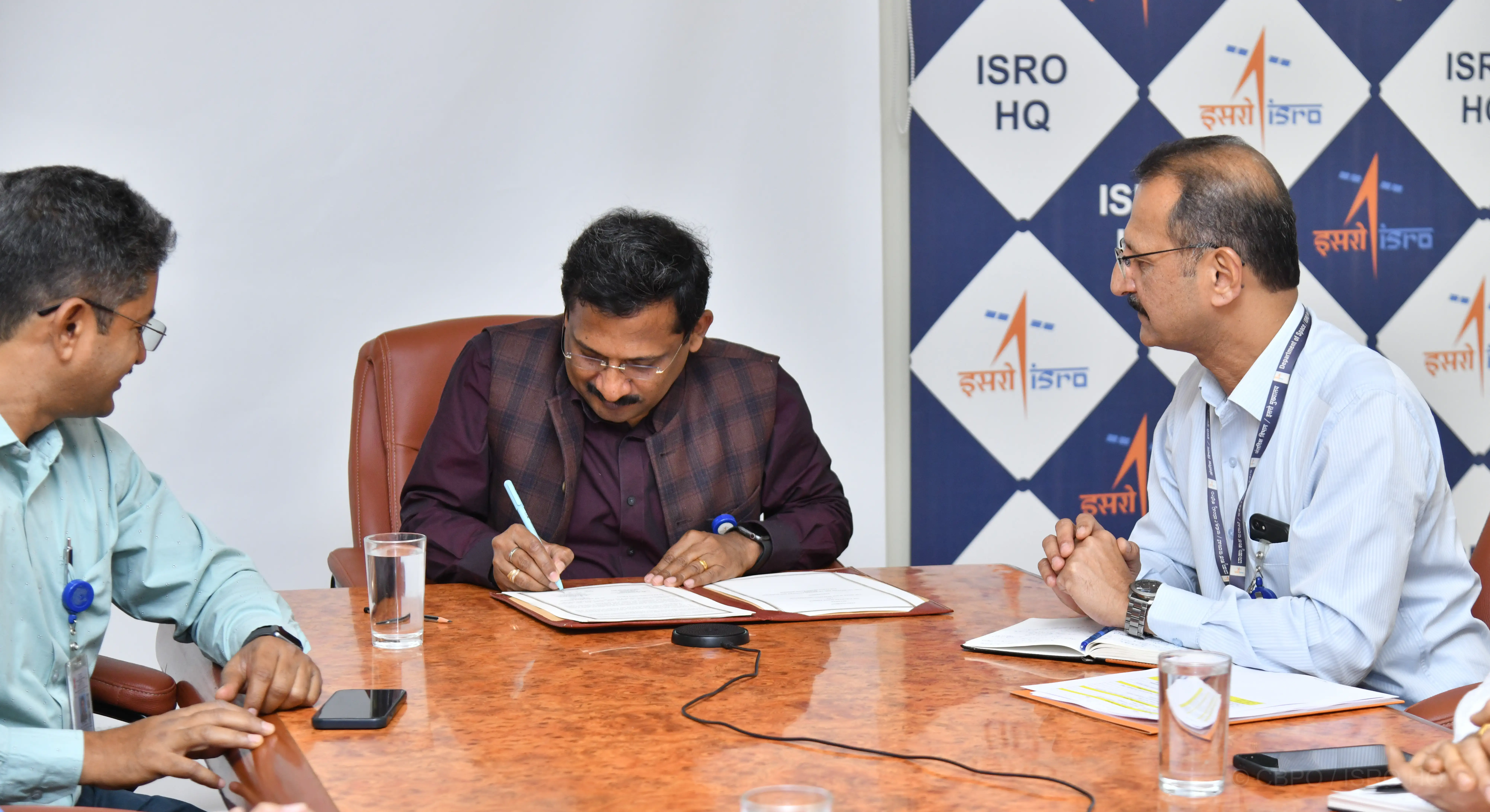 Scientific Secretary signing the agreement and ISRO team realising the instrument
                                        